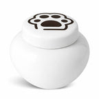 Witte keramische kattenurn met zwarte pootafdruk op het deksel
