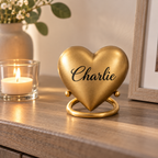 De laatste aai hartvormige mini urn in mat goud met gepersonaliseerde naam op een standaard in een sfeervol interieur