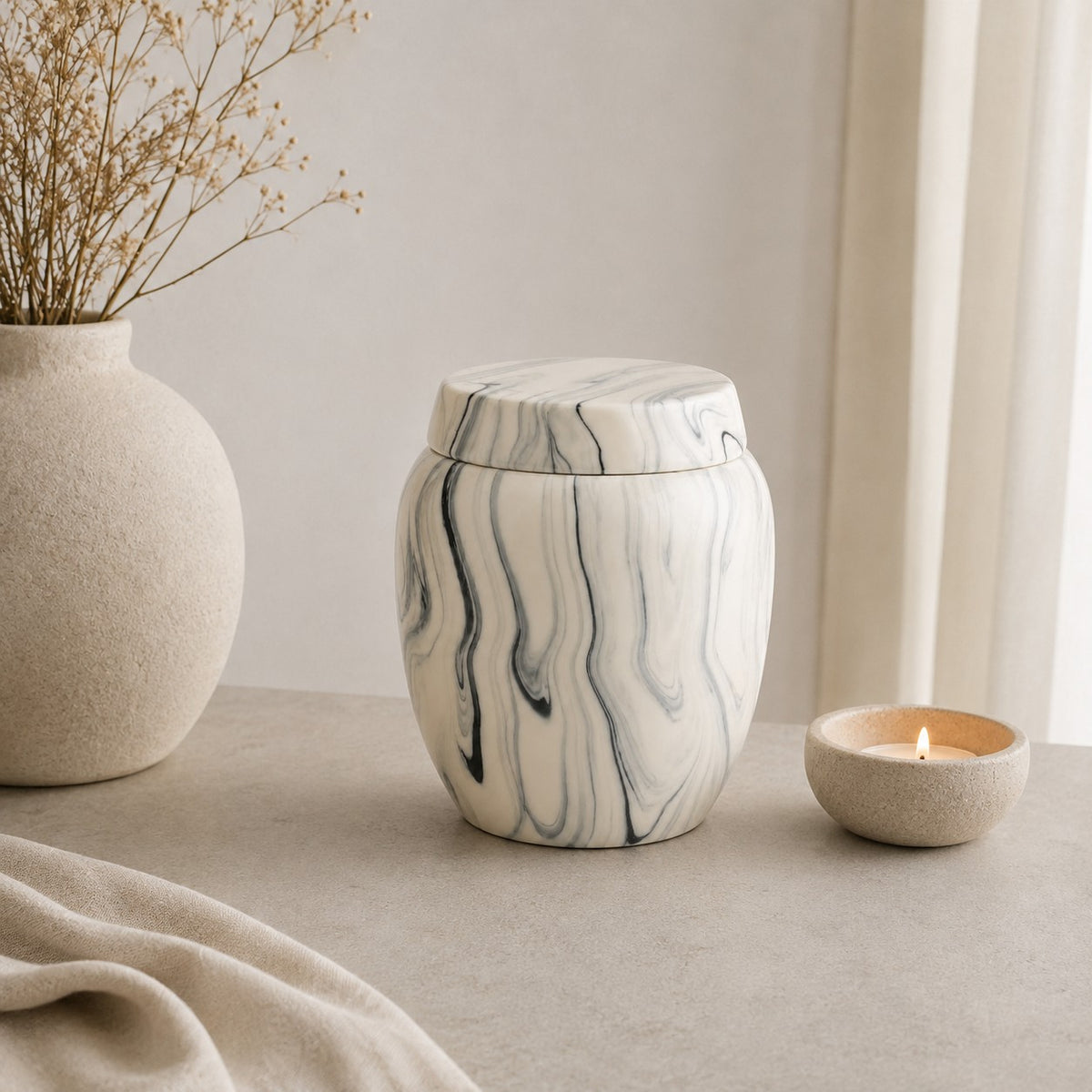 De laatste aai keramische urn met grijs-witte marmerlook en minimalistisch design op een sfeervolle tafel.