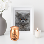 De laatste aai roségouden RVS mini-urn met inscriptie voor as van huisdieren naast een fotolijst en kaars