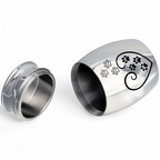 De laatste aai mini urn van RVS in zilver en zwart met een hartvormig pootafdruk design voor huisdieren.