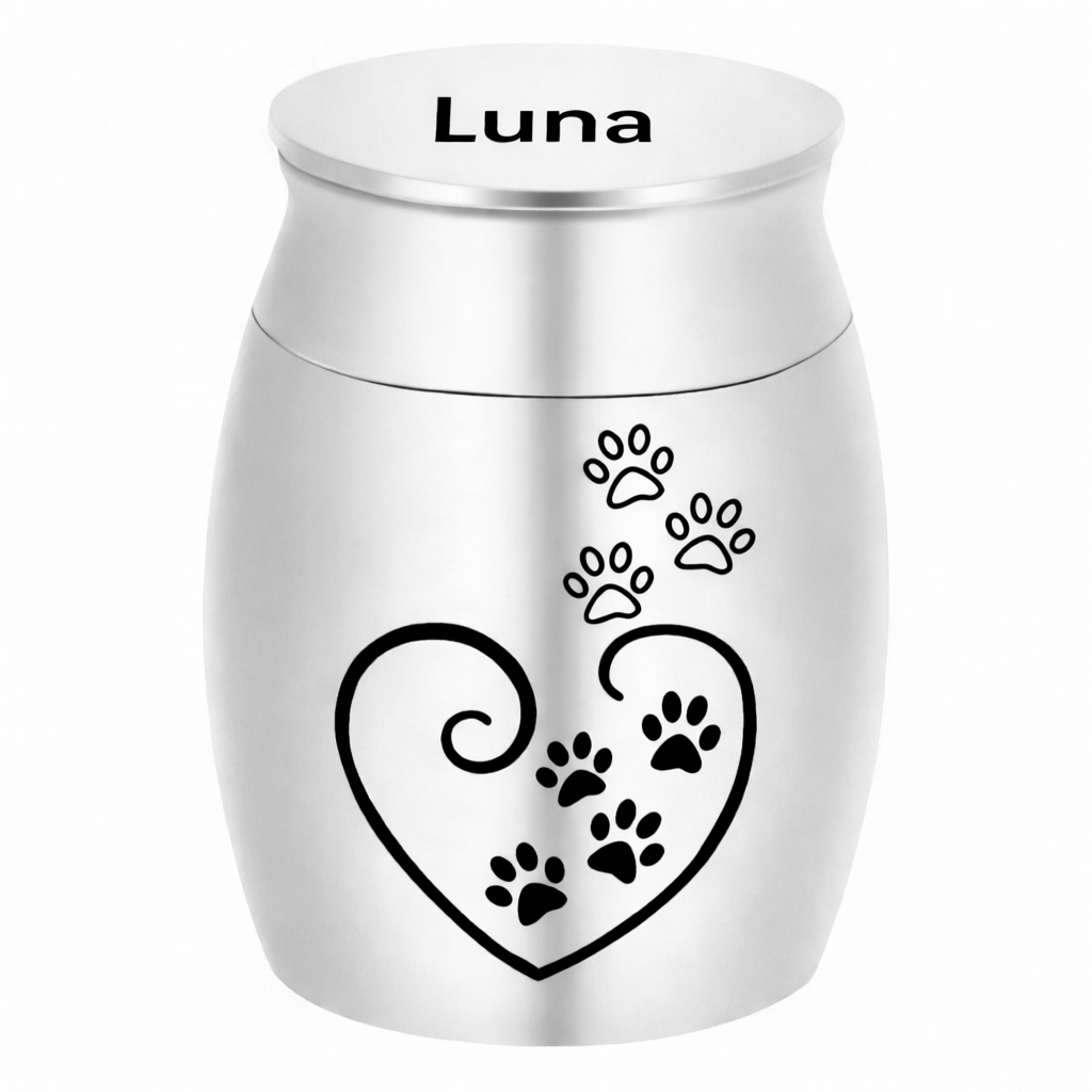 De laatste aai zilverkleurige RVS mini-urn met hart en pootafdrukken en de naam Luna gegraveerd op de deksel.