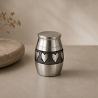De laatste aai zilverkleurige RVS mini urn voor huisdieren met een verfijnd hartjespatroon voor as of haarlok.
