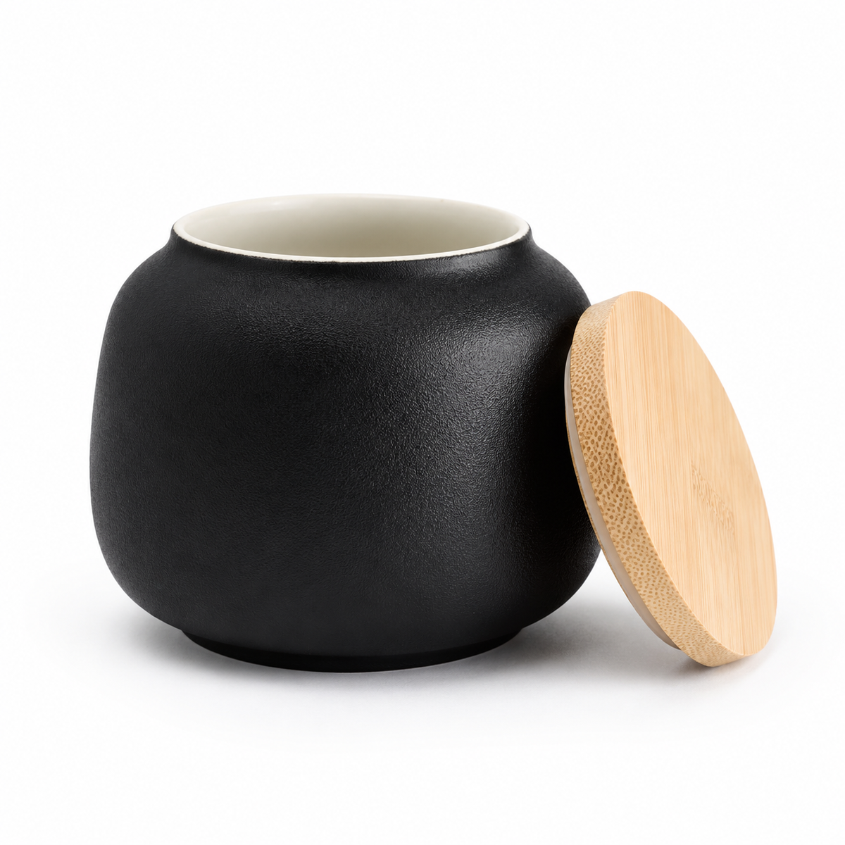 De laatste aai zwarte keramische mini-urn voor honden met een natuurlijk bamboe deksel op een witte achtergrond