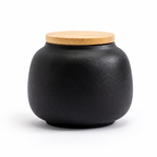 Zwarte keramische mini-urn van De laatste aai met een bamboe deksel voor het bewaren van as van een hond.
