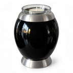 De laatste aai zwarte aluminium mini urn met glazen waxinelichthouder en zilverkleurige details voor asbestemming.